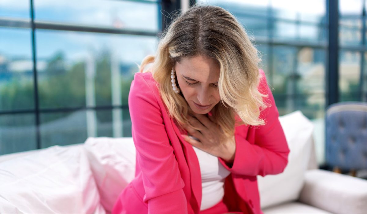 زنی با لباس صورت یکه علت تیر کشیدن سینه سمت راست دست روی قفسه سینه خود گذاشته و در محل کار است